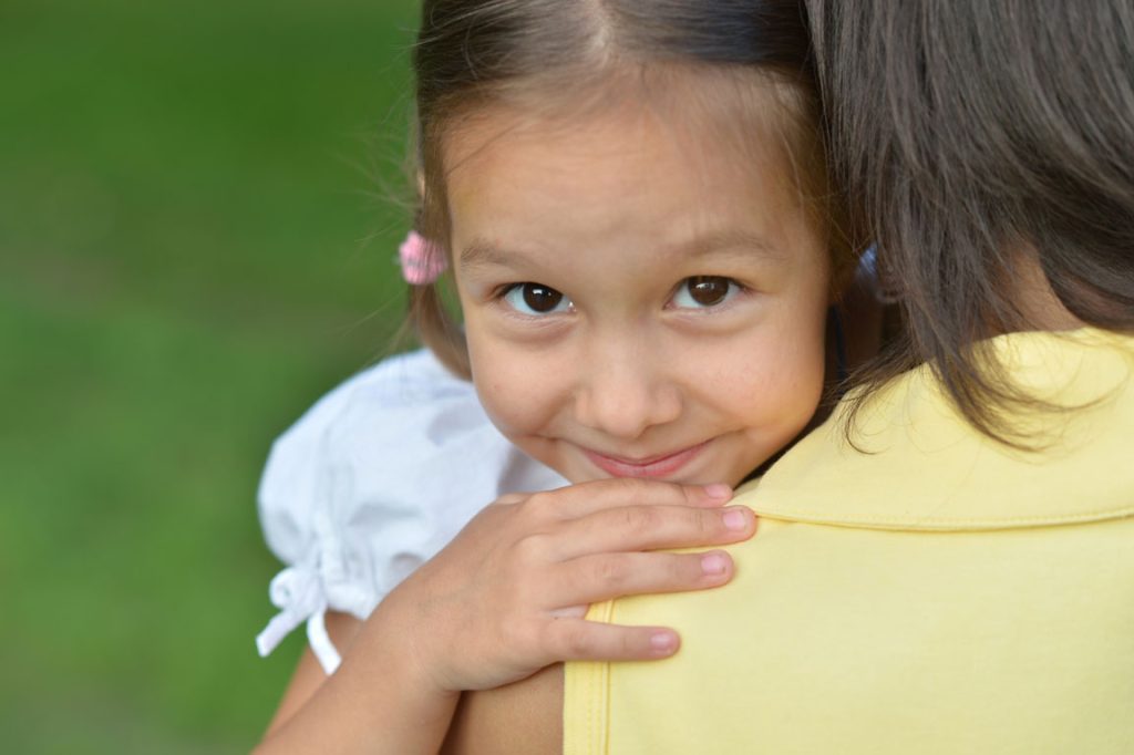 happy daughter on mother's shoulder