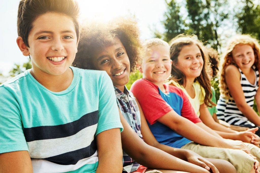 children smiling and sitting outside