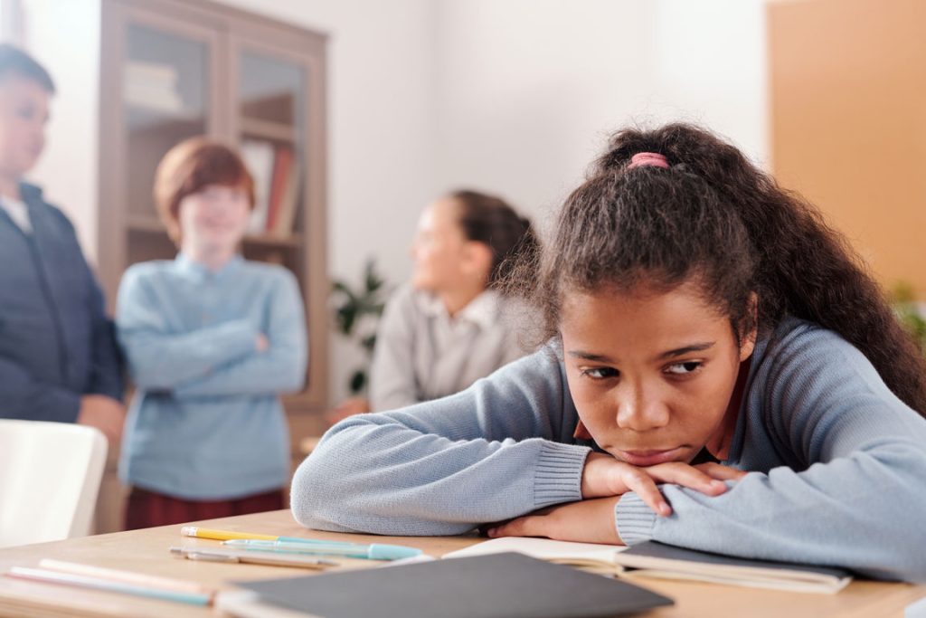 sad girl sitting at school desk